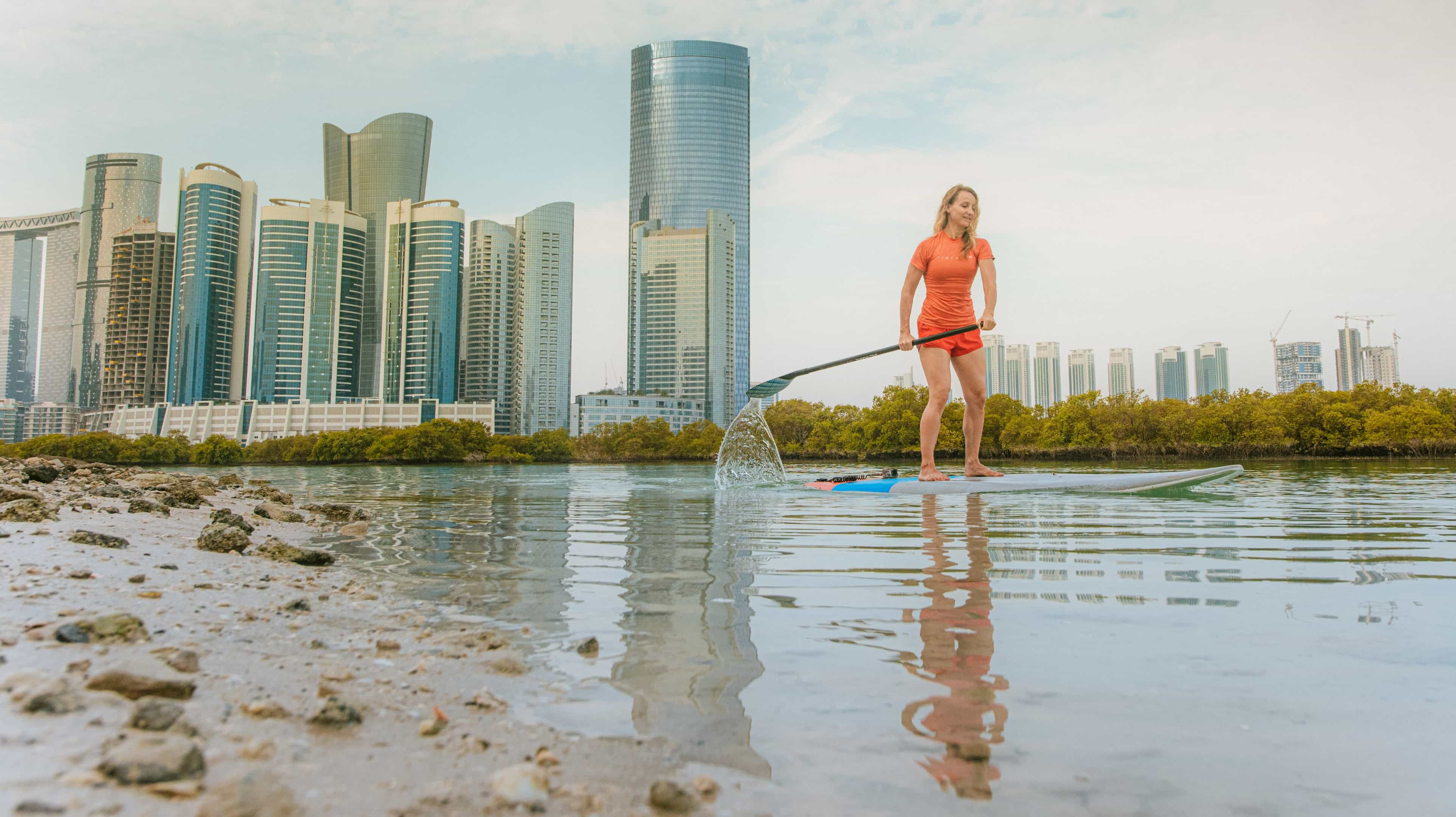 Woman stand up paddleboarding on Reem Island