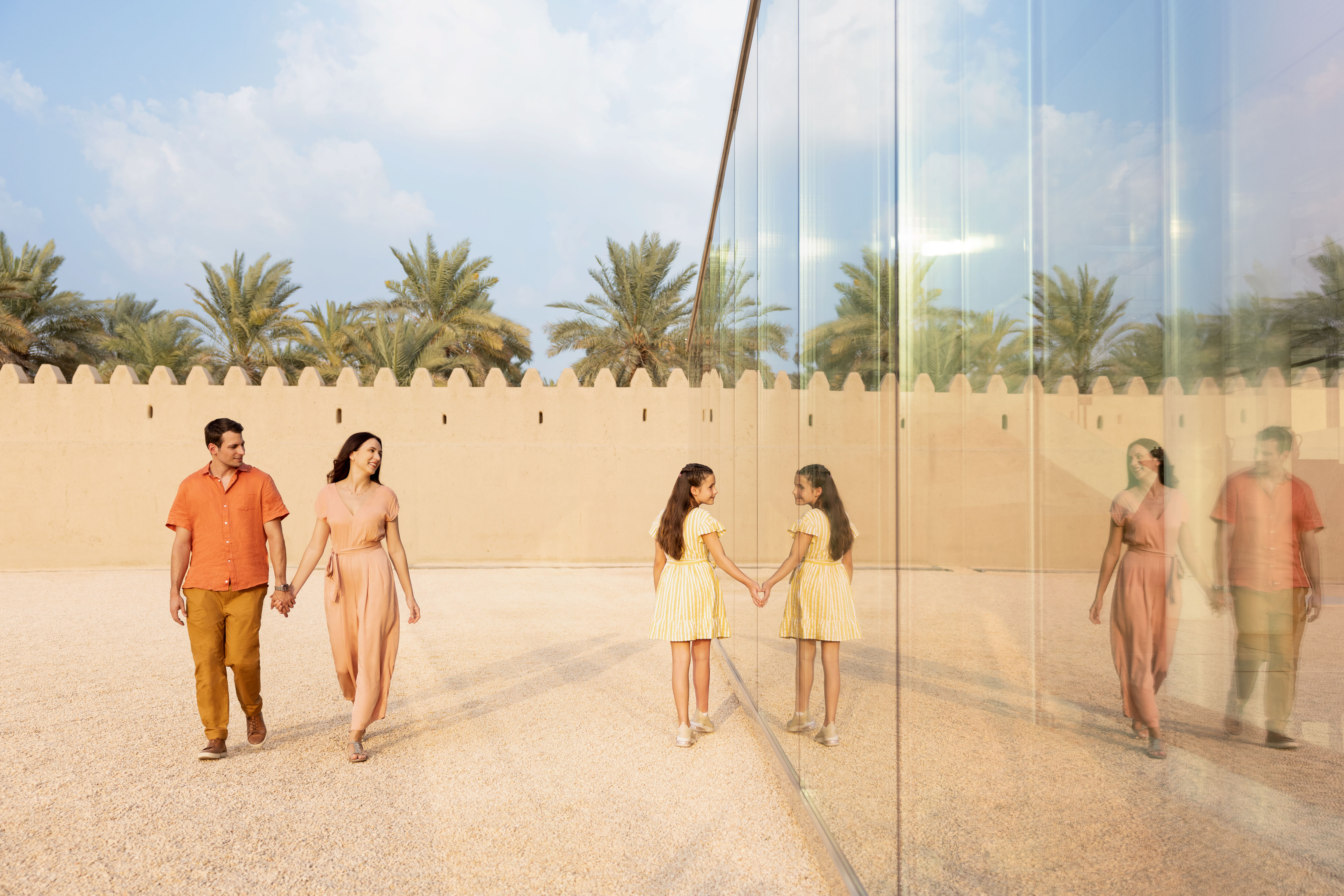 A couple and their daughter exploring Qasr Al Muwaiji